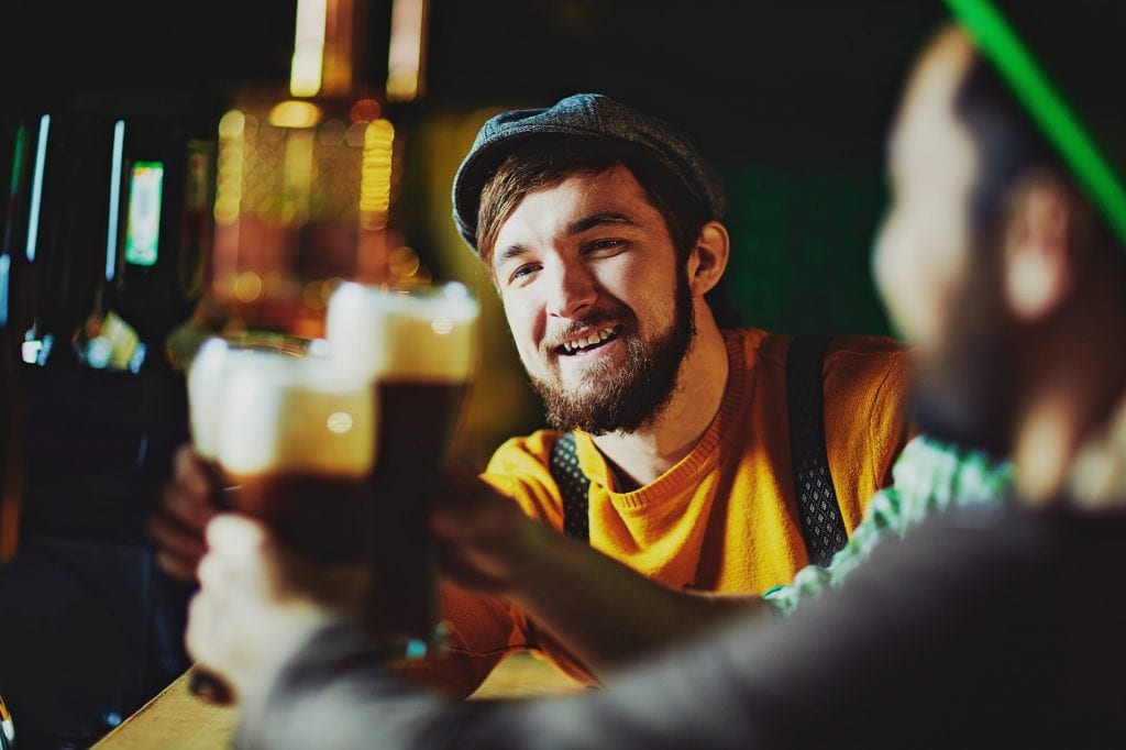 Young man toasting with his friends in pub